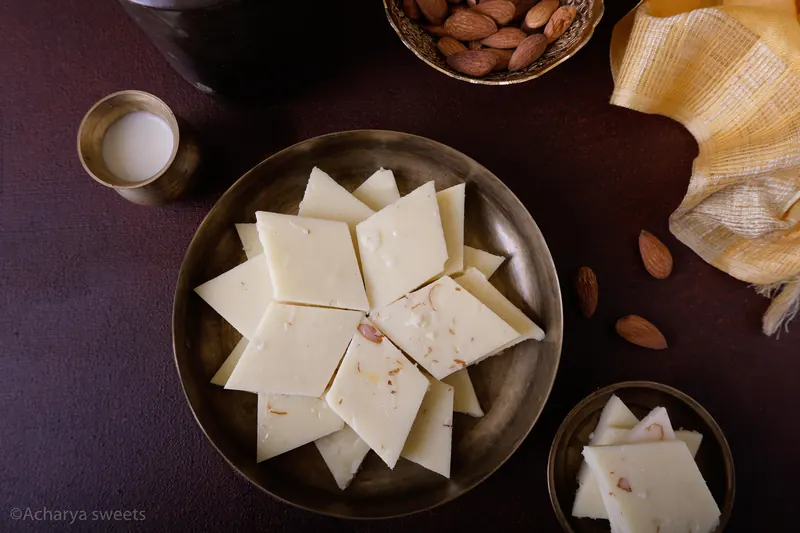 Acharya Sweet House Milk Burfi on a brass plate
