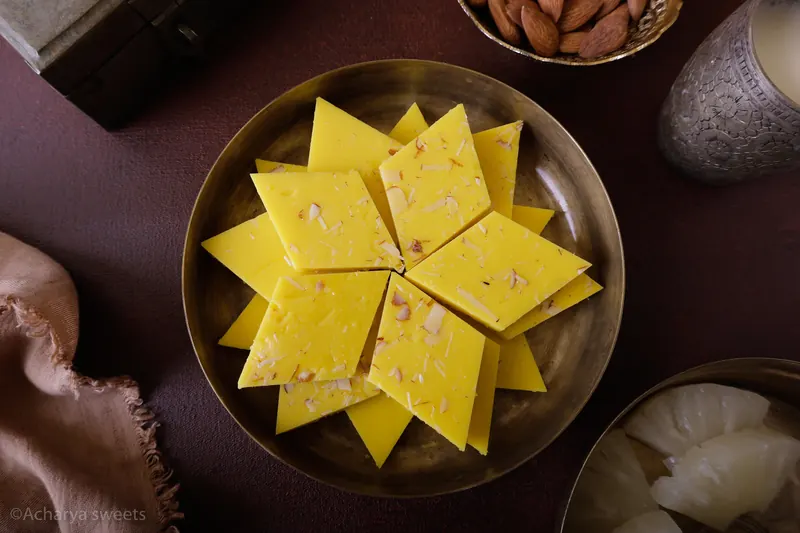 Acharya Sweet House Pineapple Burfi on a brass plate